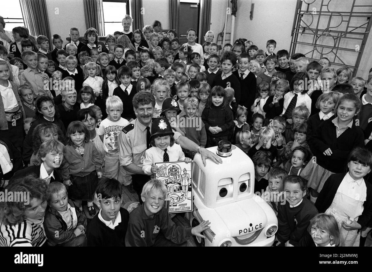 Gemma Saville a eu un cadeau spécial pour son sixième anniversaire. Gemma a rencontré Percy la voiture de police lorsqu'il a visité l'école junior et infantile du C of E de St John, Golcar. Percy, avec le PC Alan Laurie, agent de prévention des accidents de HUDDERSFIELD, est allé à l'école pour faire passer aux enfants les messages de sécurité routière et de danger étranger. Les enfants de PlaySchool se sont joints à la visite. Tous les jeunes ont été faits membres du Club de voiture de police Percy et ont reçu un insigne et une copie du Code de la Croix verte. 12th septembre 1990. Banque D'Images