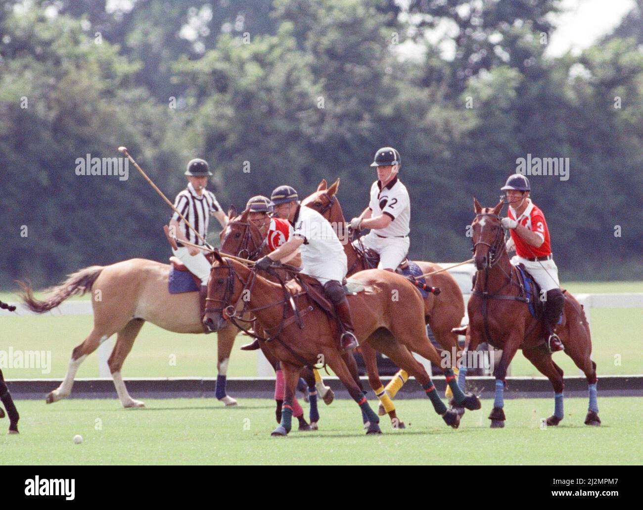 Le Prince Charles (maillot rouge portant le numéro 3) a été enfermé dans une bataille féroce contre le Major James Hewitt, ami de la princesse Diana aujourd'hui (maillot blanc portant le numéro 2) , sur le terrain de polo. À une étape, comme le major Hewitt a défié le prince, le commentateur a exclamé 'Oh, je dis ! Cette sortie était un peu difficile » malgré la détermination de Charles, l'équipe du héros du Golfe a remporté 4-1 victoires à Windsor. Les prix du polo ont été remis par une autre royale, la princesse Beatrice, fille de deux ans de la duchesse de York et du prince Andrew. Photo prise le 16th juillet 1991 Banque D'Images