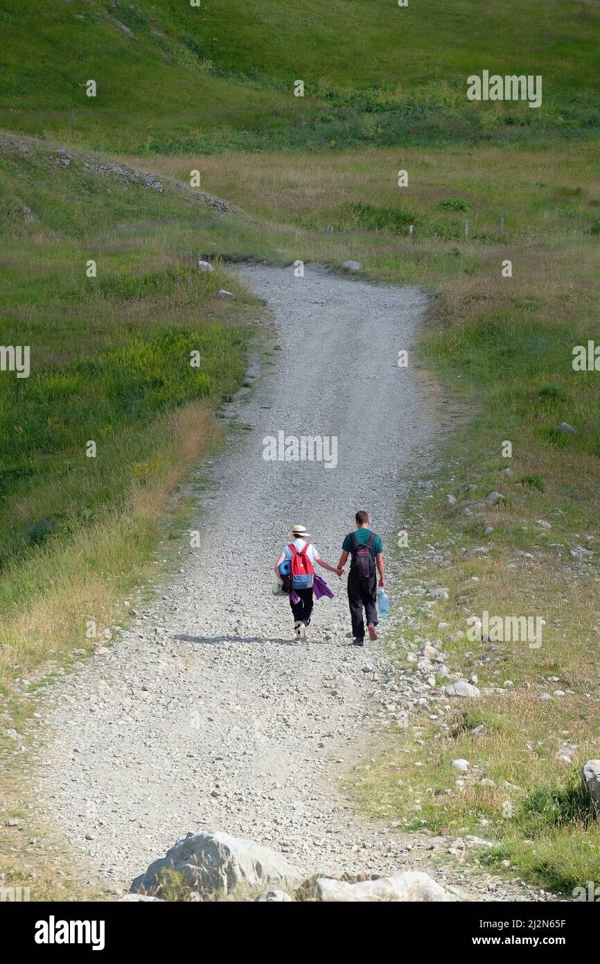 Jeune couple de randonneurs avec sac à dos main dans la main sur le chemin pierreux, Monténégro Banque D'Images