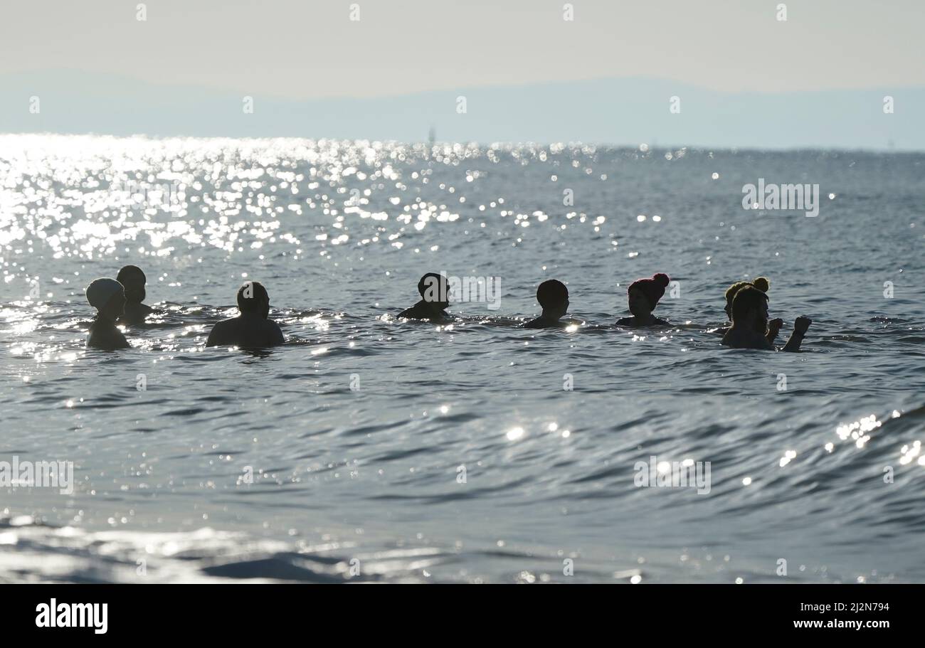 Les gens nagent dans la mer au large de la plage de Boscombe à Dorset. Date de la photo: Dimanche 3 avril 2022. Banque D'Images