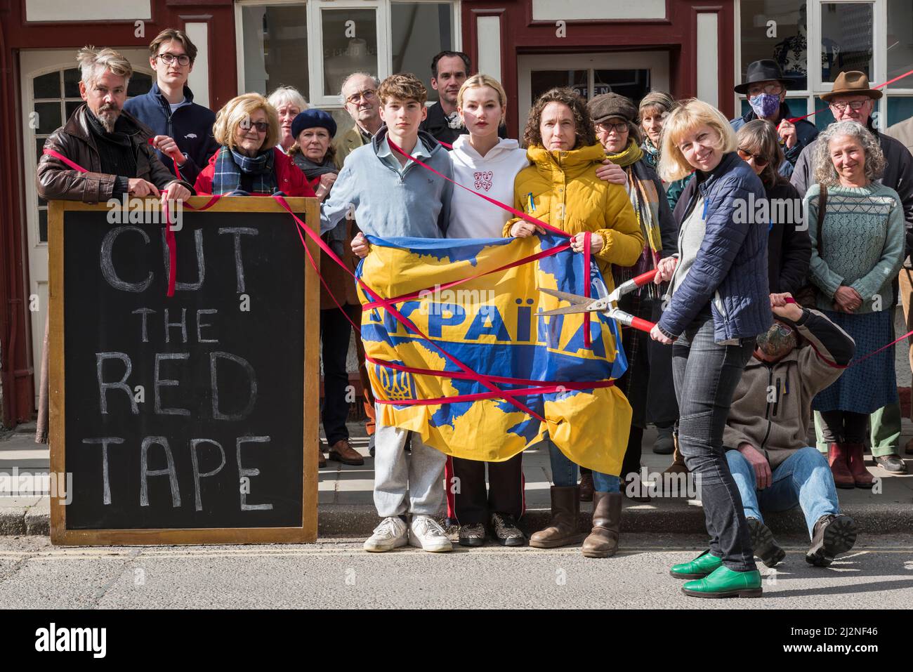 Une manifestation en faveur des réfugiés ukrainiens dans la petite ville galloise de Presteigne, Powys, Royaume-Uni, le 2/4/22. Ellie Mathieson, couturière ukrainienne (brandissant les ciseaux rouges) et Louisa Collings (en jaune), toutes deux de Presteigne, pressent le Home Office de couper la paperasserie sur les demandes de visa de réfugié. La famille Louisa sponsorise avec l’aide d’Ellie attend depuis deux semaines à Varsovie, au cours desquelles le garçon de 12 ans est tombé malade et a fini à l’hôpital sur un goutte-à-goutte. « Cette limbe que nous leur infligons ne fait qu’ajouter à leur traumatisme », explique Louisa Banque D'Images