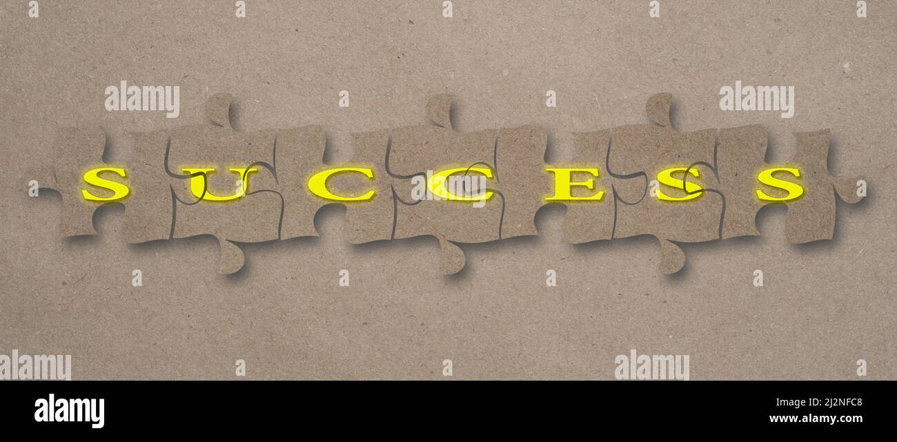 Mot de réussite assemblé sur des pièces de puzzle sur un fond de papier artisanal. Banque D'Images