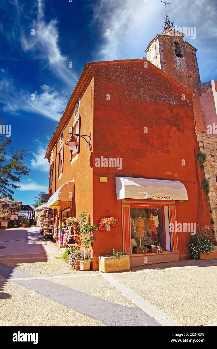 Roussillon, France - octobre 9. 2019: Vue sur la place de l'ancien village sur l'ocre coloré maison en pierre naturelle et l'église médiévale clocher contre Banque D'Images