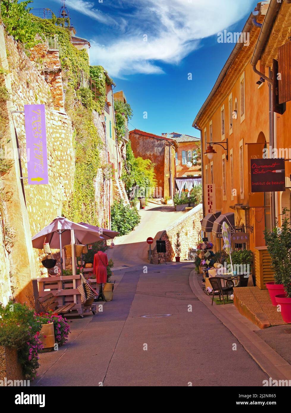 Roussillon en Provence, France - octobre 2. 2019: Vue sur la rue de l'allée avec mur de pierre naturelle de la forteresse et des maisons jaunes d'ocre méditerranéen de nouveau Banque D'Images