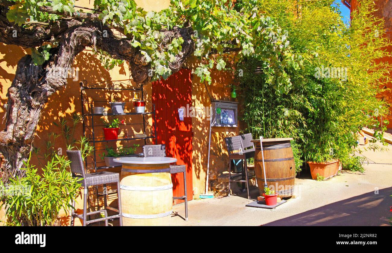 Roussillon, France - octobre 9. 2019: Vue sur la campagne colorée idyllique naturelle ocre maison en pierre style provençal, porte rouge, tonneaux à vin, jardin vert wi Banque D'Images