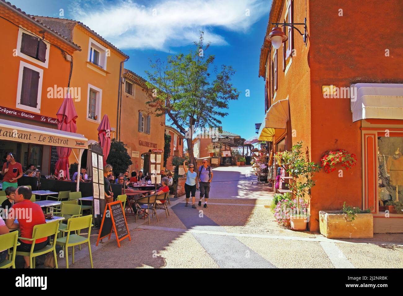 Roussillon, France - octobre 9. 2019: Vue sur la place avec des personnes assis à l'extérieur du café dans le vieux village médiéval coloré avec des maisons ocre Banque D'Images