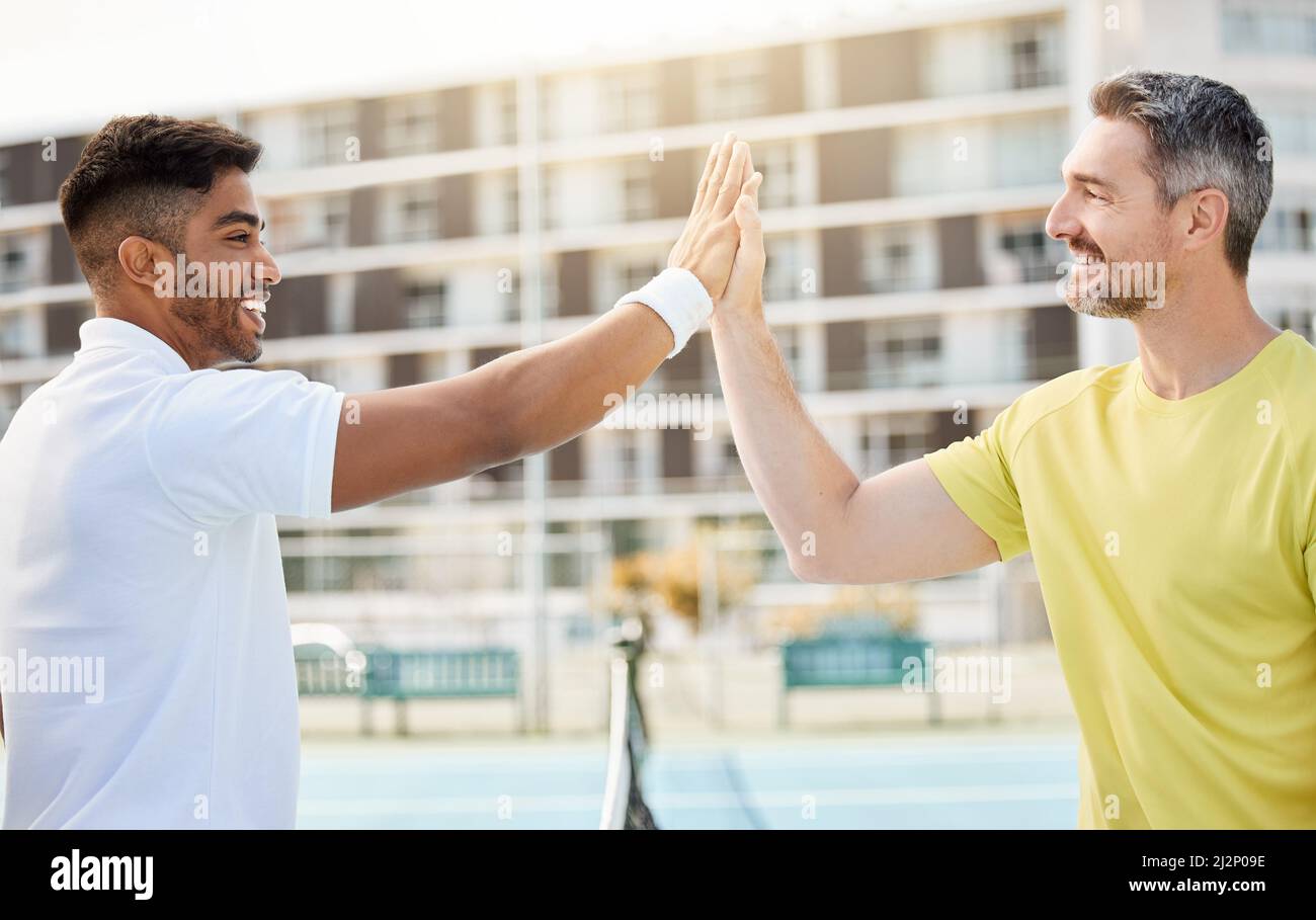Vous avez dominé ce jeu. Coupe courte d'un jeune homme de tennis en haut qui a mis son entraîneur en train de se tenir debout sur un court. Banque D'Images