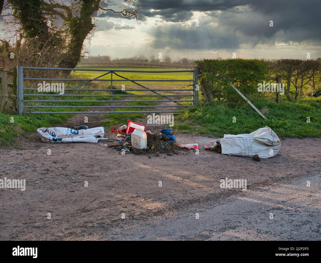 Déchets domestiques rejetés illégalement à l'entrée d'un champ agricole en hiver. Prise dans le nord-ouest du Royaume-Uni. Banque D'Images