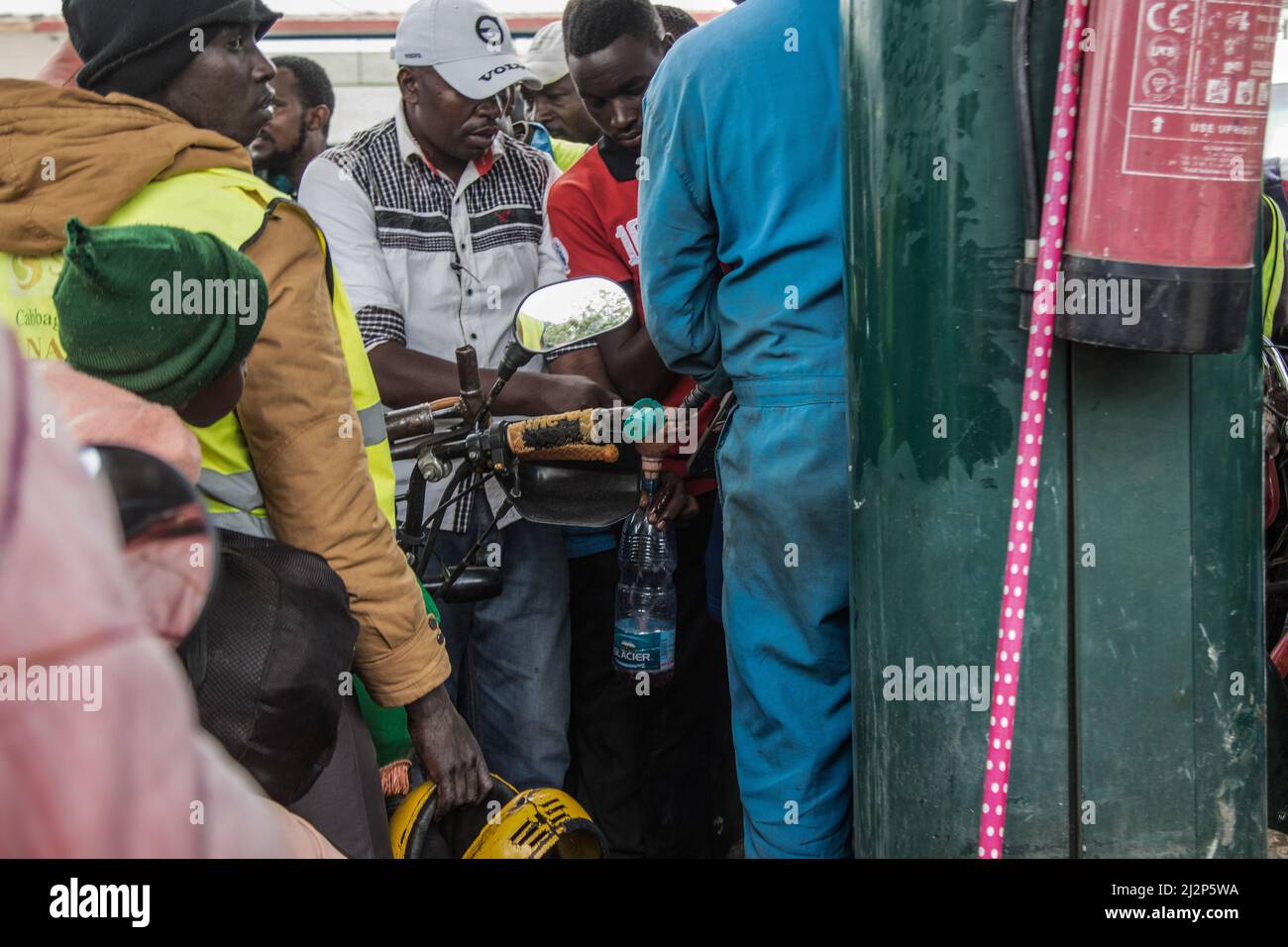 Nakuru, Kenya. 02nd avril 2022. Un préposé remplit une bouteille en plastique d'huile pendant que d'autres motocyclistes attendent. Le Kenya a été frappé par une importante pénurie de pétrole avec de longues files d'attente par les automobilistes qui attendent d'être servis dans quelques stations-service qui ont encore la marchandise essentielle. Le Kenya Energy and Petroleum Regulatory (EPRA) a attribué la pénurie à des défis logistiques sans précédent. Les prix mondiaux du pétrole ont été affectés dans le sillage de la guerre Russie-Ukraine qui a fait grimper le prix à 14 ans. (Photo de James Wakibia/SOPA Images/Sipa USA) crédit: SIPA USA/Alay Live News Banque D'Images