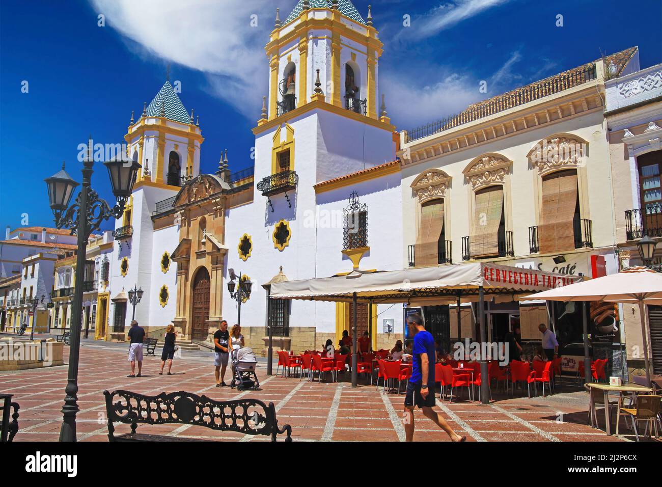 Ronda (plaza del socorro), Espagne - Mai 9. 2019: Vue sur la place avec café extérieur bar-restaurant sur l'église blanche médiévale avec 2 clochers, bleu sk Banque D'Images