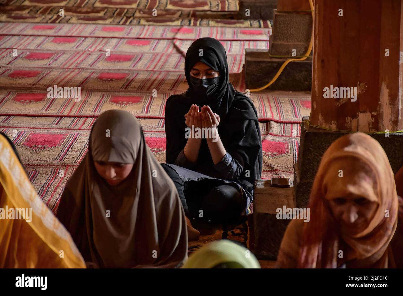 Srinagar, Inde. 03rd avril 2022. Une fille cachemiri prie à l'intérieur de la Jamia Masjid ou Grande Mosquée pendant le premier jour du Ramadan à Srinagar. Les musulmans du monde entier marquent le mois du Ramadan, le mois le plus sacré du calendrier islamique au cours duquel les fidèles jeûnent de l'aube au crépuscule. Crédit : SOPA Images Limited/Alamy Live News Banque D'Images