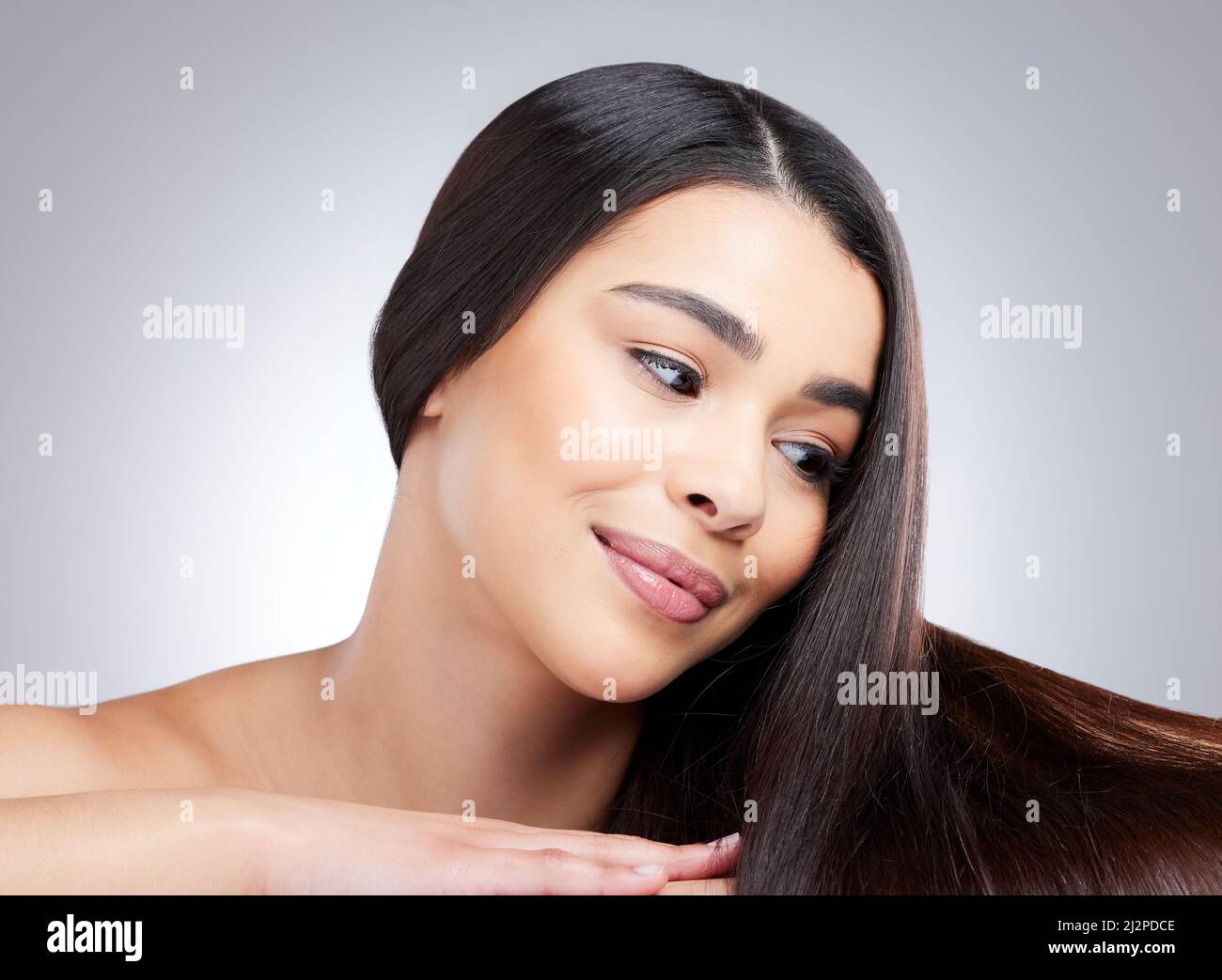 Une véritable beauté en spectacle. Photo en studio d'une jeune femme attrayante posant sur un fond gris. Banque D'Images