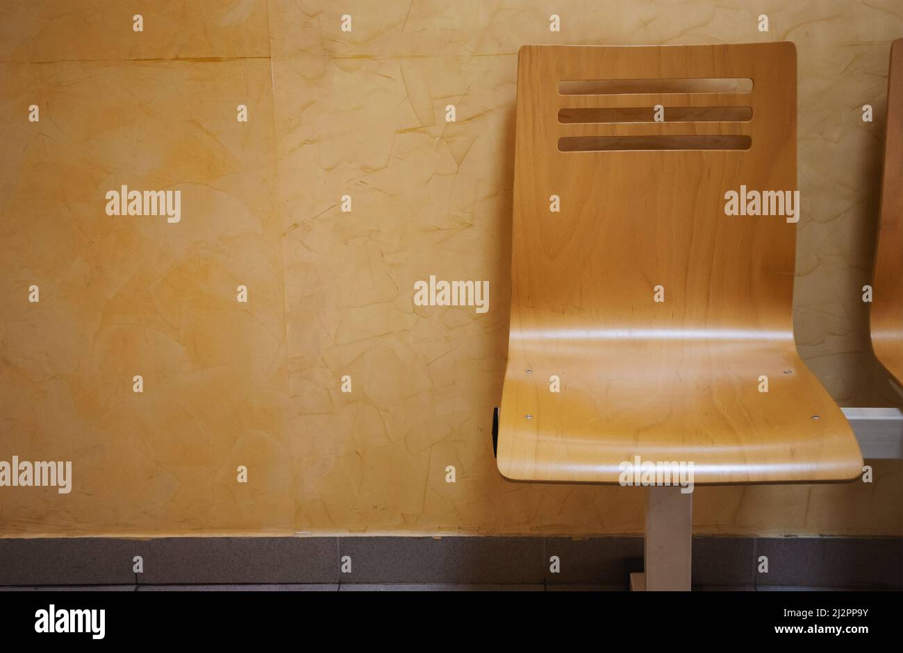 Chaises vides en bois devant le mur, partie de la salle d'attente. Banque D'Images