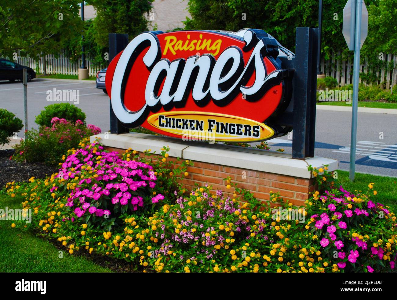 Panneau Cane's Chicken Fingers entouré d'un lit de fleurs à Lakewood, Ohio Banque D'Images
