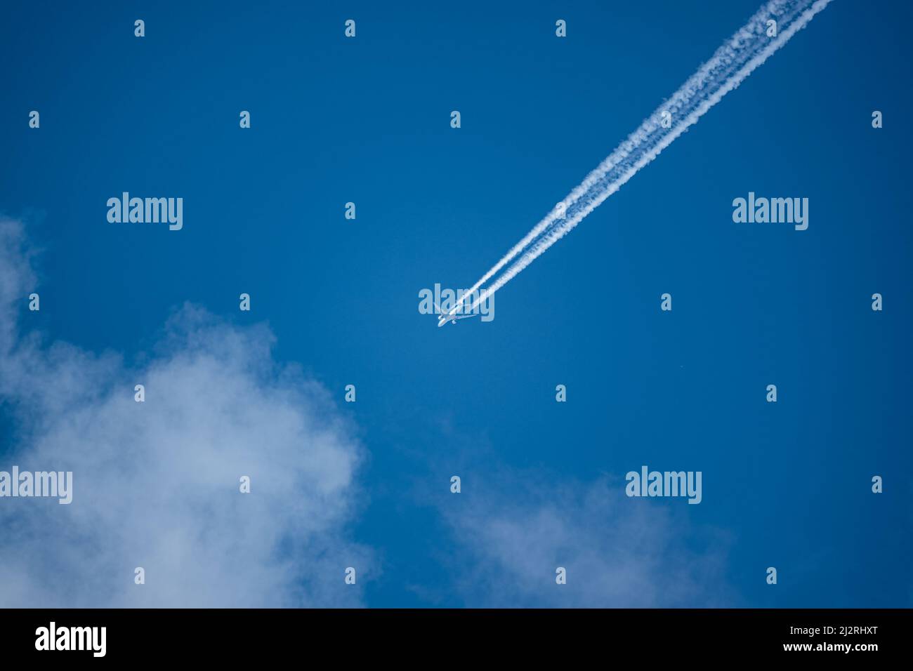 En regardant un avion à moteur double KLM 7878 dreamliner dans un ciel bleu profond avec des traces de vapeur diagonalement sur le châssis Banque D'Images