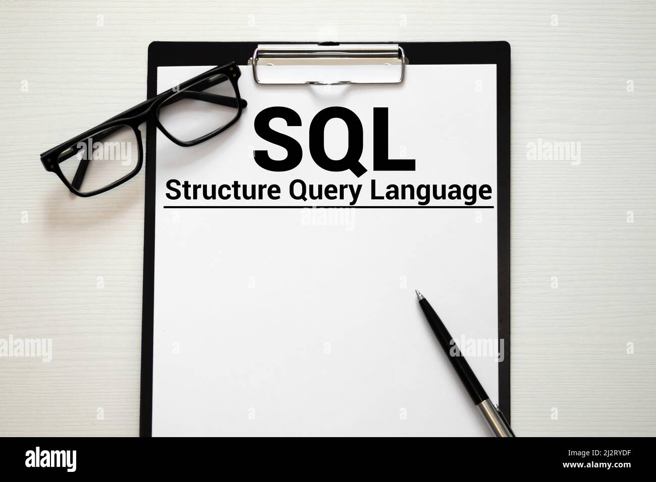 Langage de requête structuré SQL écrit dans le bloc-notes sur une table blanche. Banque D'Images