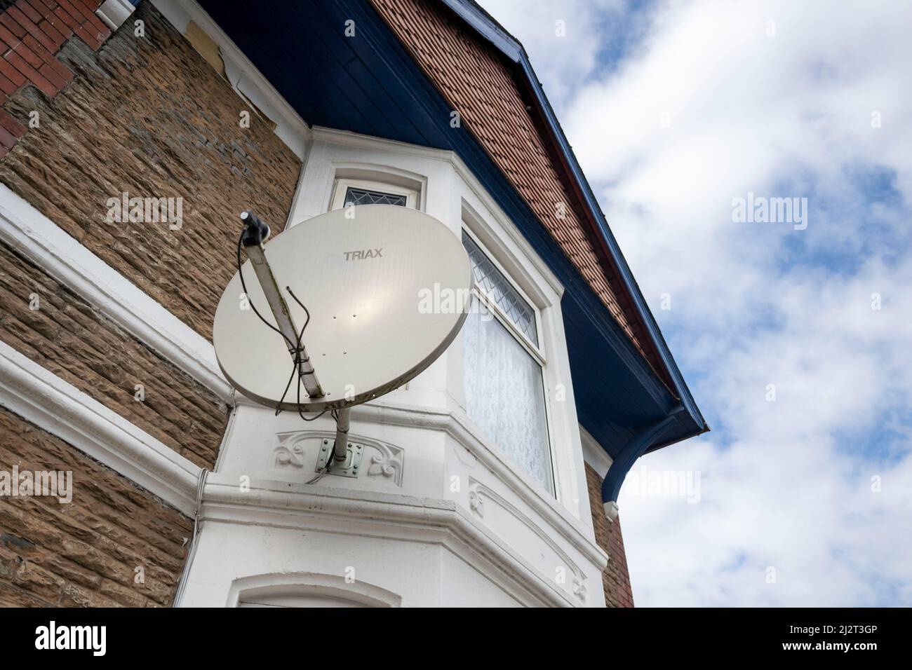 Une antenne parabolique sur le côté d'une propriété résidentielle à Cardiff, pays de Galles, Royaume-Uni. Banque D'Images
