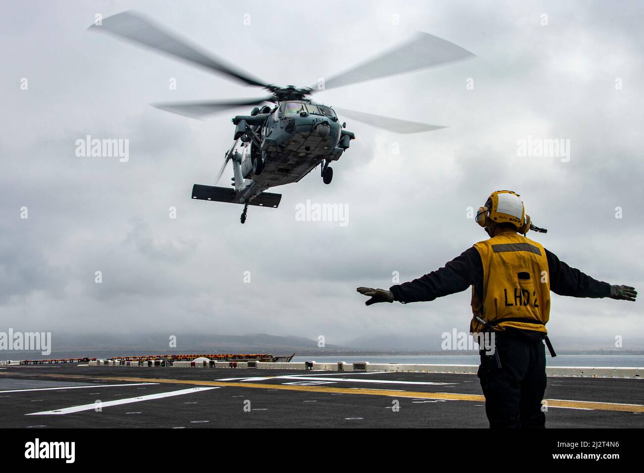 OCÉAN PACIFIQUE (31 mars 2022) Aviation Boatswain’s Mate (Handling) Airman Garrett Solomon, originaire d’Ewa Beach, Hawaii, affecté au navire d’assaut amphibie USS Essex (LHD 2), envoie un signal à un hélicoptère MH-60s Sea Hawk attaché à l’Escadron de combat en mer (HSC) 21 lors d’opérations de déchargement d’munitions à bord d’Essex, le 31 mars 2022. Essex mène actuellement des opérations de routine dans la flotte américaine 3rd. (É.-U. Navy photo par Mass communication Specialist 3rd Class Isaak Martinez) Banque D'Images