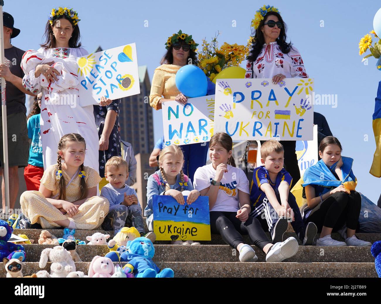 St. Louis, États-Unis. 03rd avril 2022. Les enfants s'assoient sur les marches de l'arche de la porte avec des signes de soutien, derrière eux à Saint-Louis le dimanche 3 avril 2022. La communauté ukrainienne s'est réunie à l'Arche, avec des animaux en peluche donnés, représentant les centaines d'enfants qui ont été tués lors de l'invasion russe actuelle. Le rassemblement comprenait des mots d'encouragement, des prières et de la musique ukrainienne. Photo par Bill Greenblatt/UPI crédit: UPI/Alay Live News Banque D'Images