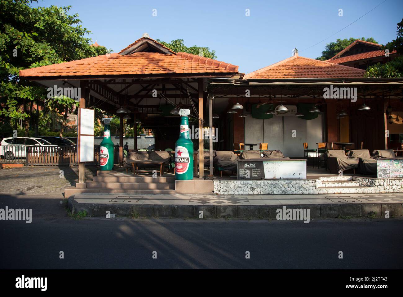 Jalan Kartika Plaza à Kuta, Bali avec sa célèbre bouteille de bière Kabar Grill Bintang sur la gauche. Banque D'Images