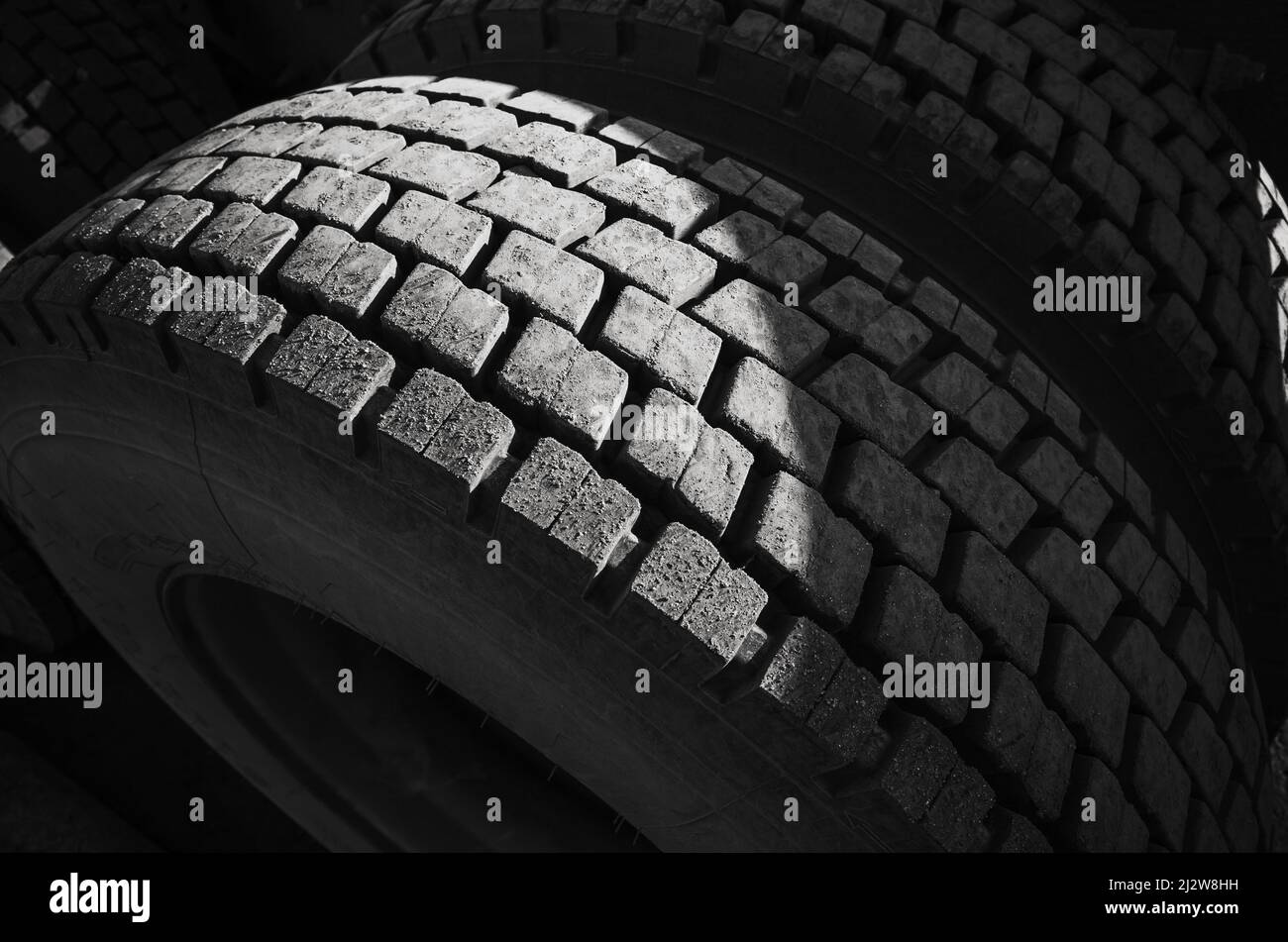Roue de camion de chargement sombre, photo de gros plan avec motif de pneu Banque D'Images