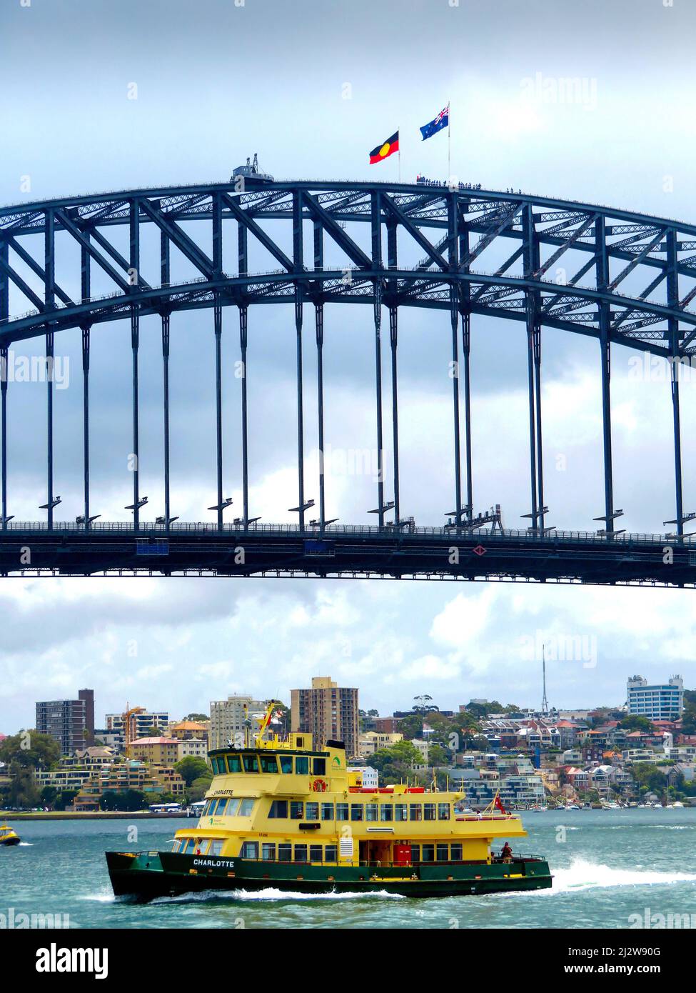 Australie, Sydney - avec le drapeau national australien et le drapeau aborigène au-dessus du pont du port, les touristes grimpent sur le pont en acier, qui Banque D'Images