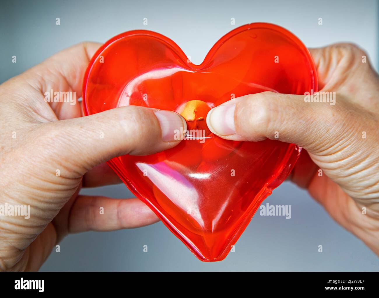 Forme de coeur du pack thermique réutilisable. Chauffe-mains en forme de coeur rempli de gel apaisant est une promotion parfaite des soins de santé. Fixez la tablette pour activer la chaleur Banque D'Images