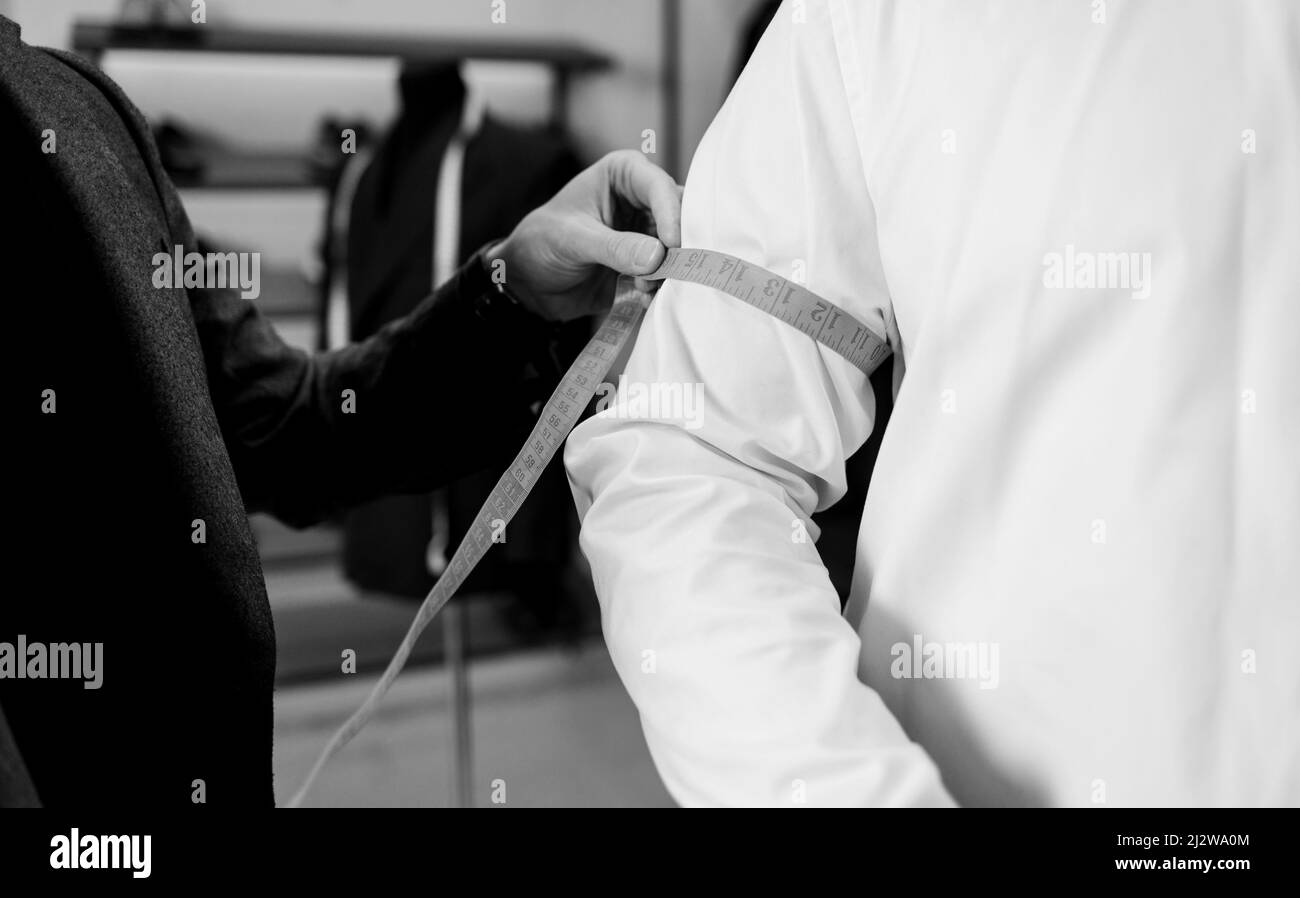 cet ancien modèle est conçu sur mesure pour prendre des mesures de poignet auprès du client dans un petit atelier d'atelier afin de créer un costume classique personnalisé Banque D'Images