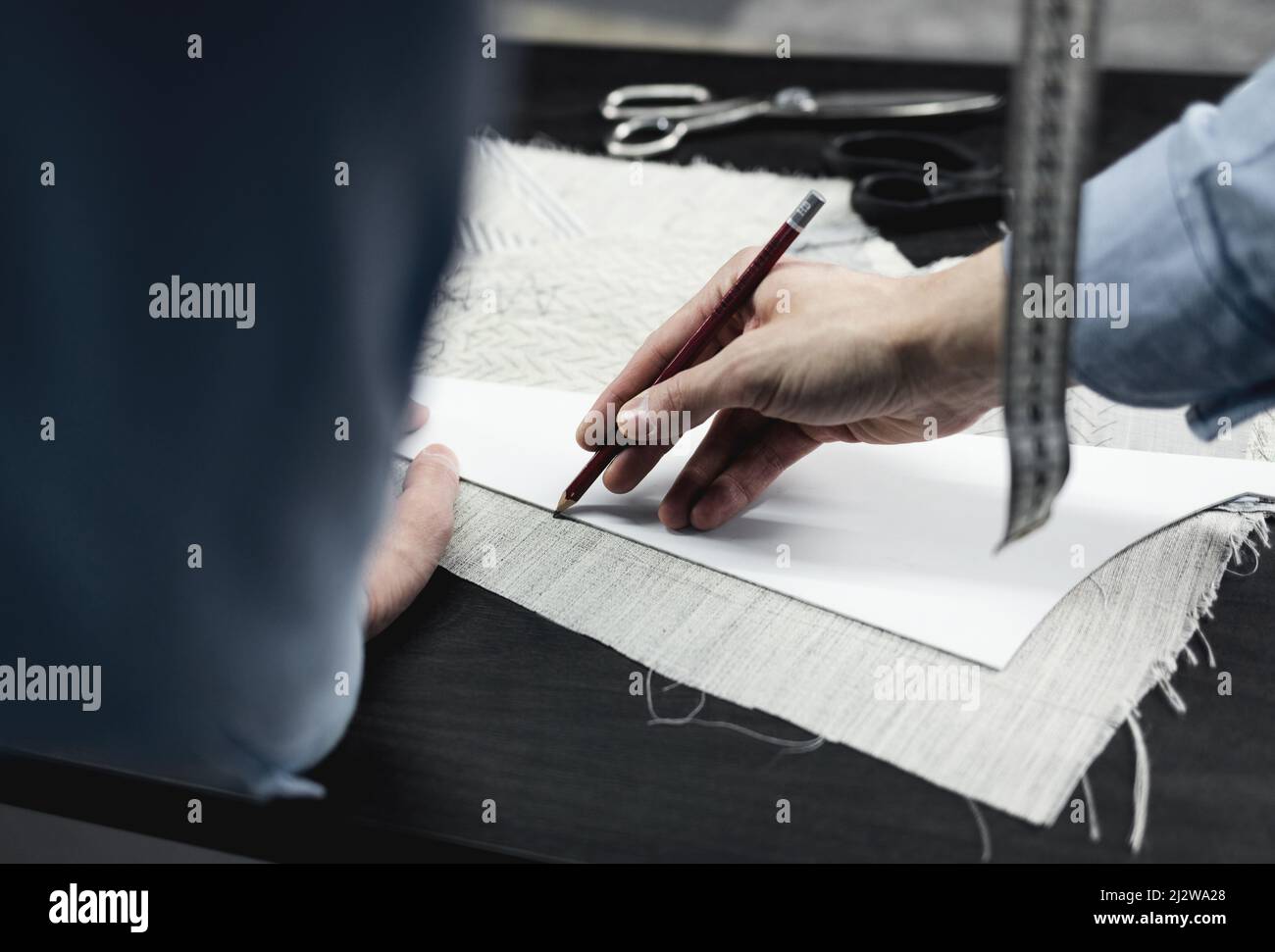 tailleur couturière crée un motif sur le tissu pour coudre des vêtements dans le studio taylor Banque D'Images