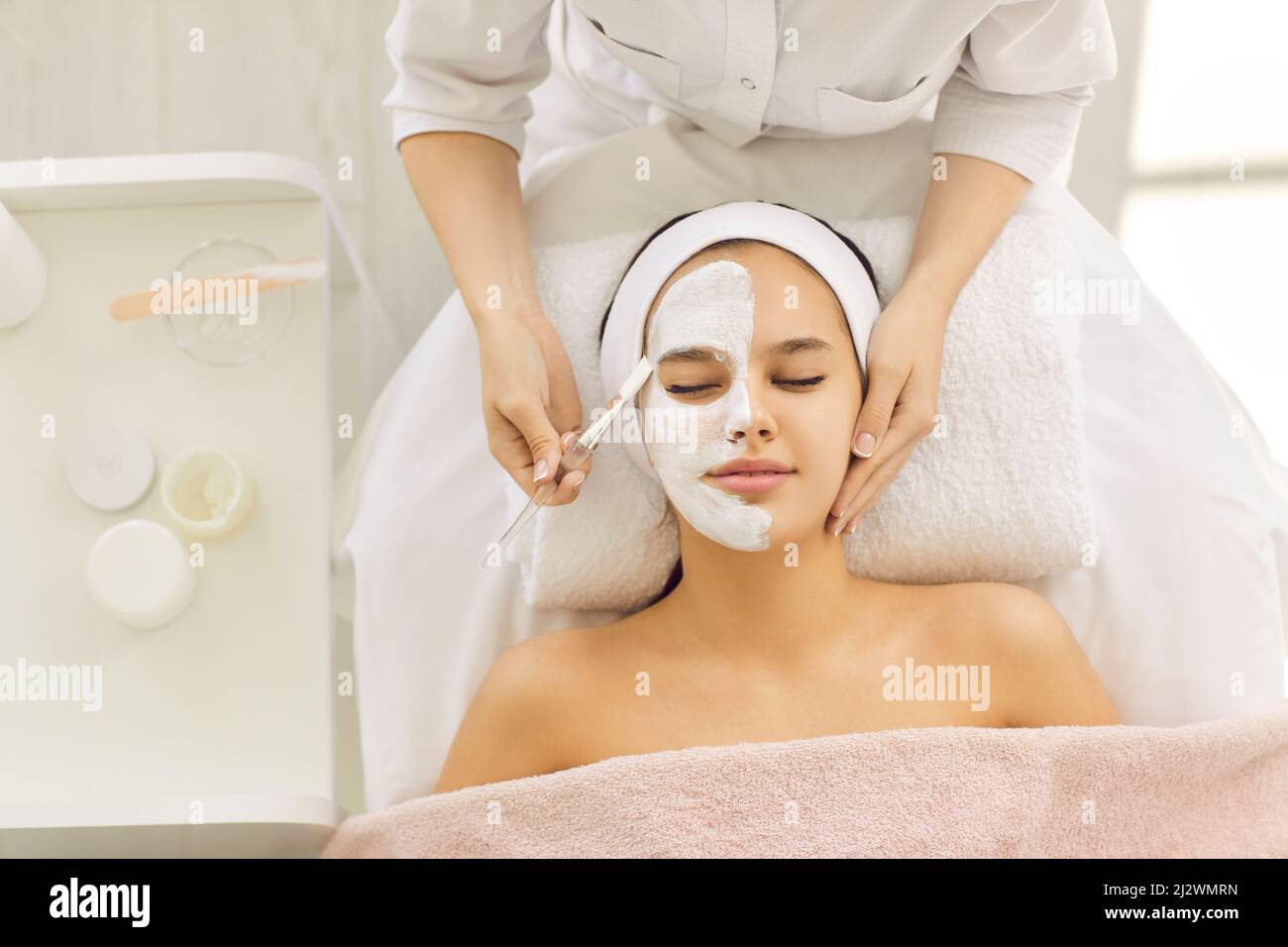 Une jeune femme belle et satisfaite utilise les services d'une esthéticienne professionnelle dans un salon de beauté ou un spa. Banque D'Images