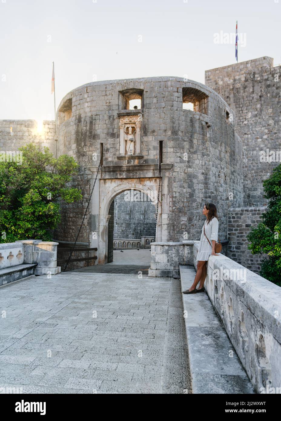 Femme aime le lever du soleil à la porte pile de la vieille ville de Dubrovnik, Dalmatie, Croatie. Banque D'Images