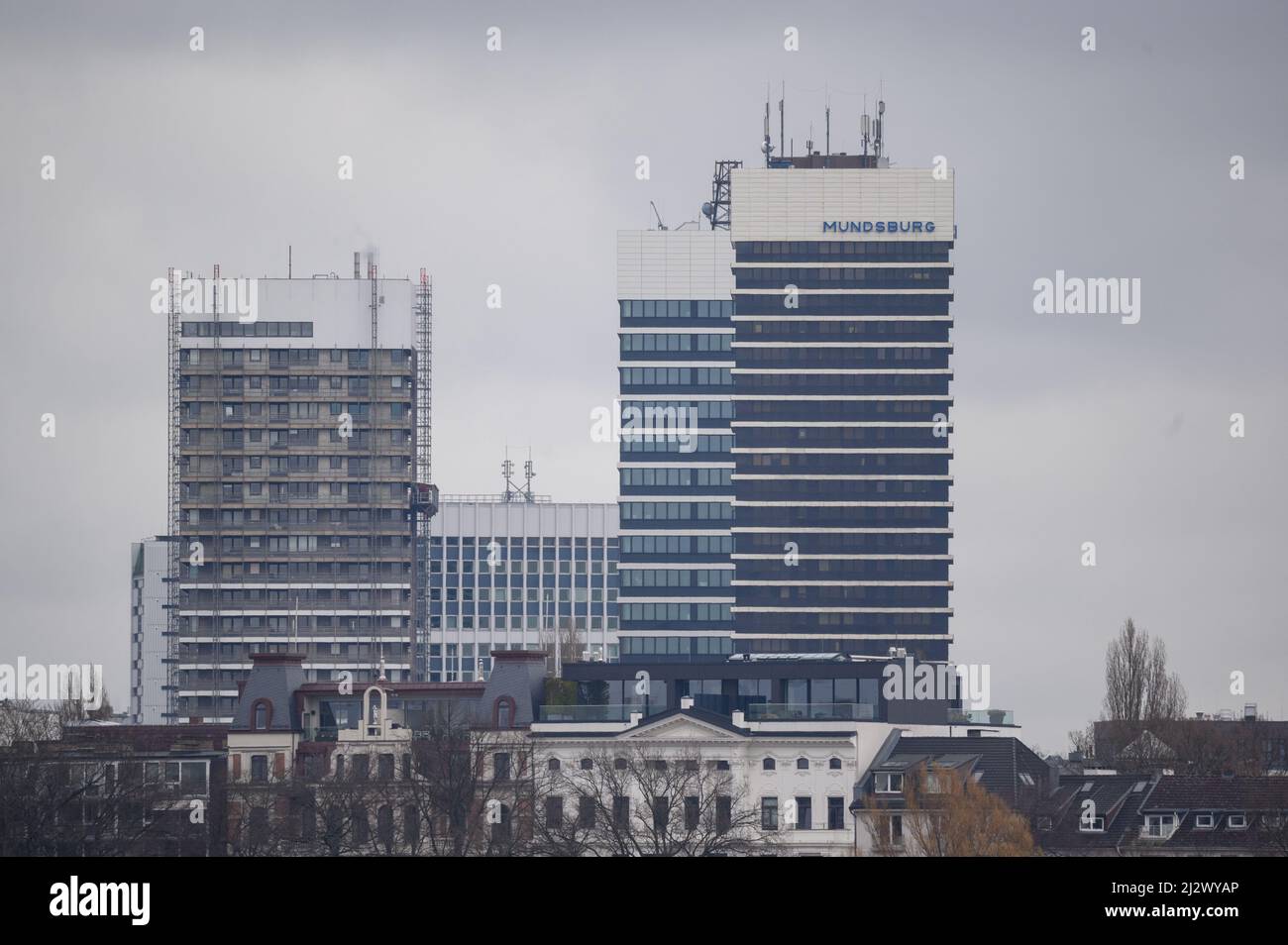 30 mars 2022, Hambourg : les tours des tours de Mundsburg sont visibles derrière des bâtiments plus résidentiels. Photo: Jonas Walzberg/dpa Banque D'Images