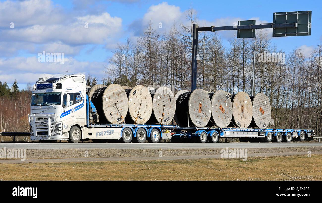 Le camion Volvo FH16 750 blanc personnalisé de T.Lahma Ky transporte des bobines de câble pour les installations au sol sur une remorque à plateau. Forssa, Finlande. 1 avril 2021. Banque D'Images