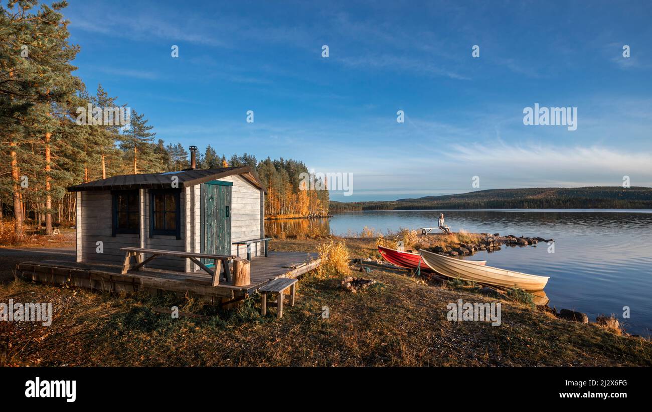 Refuge avec des bateaux sur le lac en Laponie en Suède au soleil avec un ciel bleu Banque D'Images