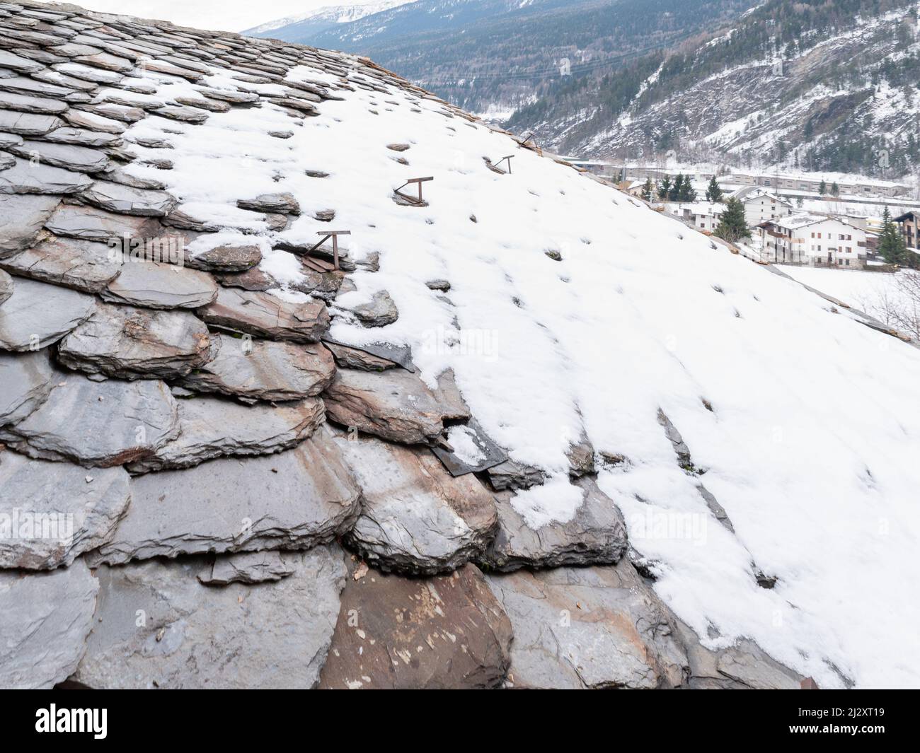 Vieux tuiles de toit gris, partiellement couvert de neige, fond. Banque D'Images