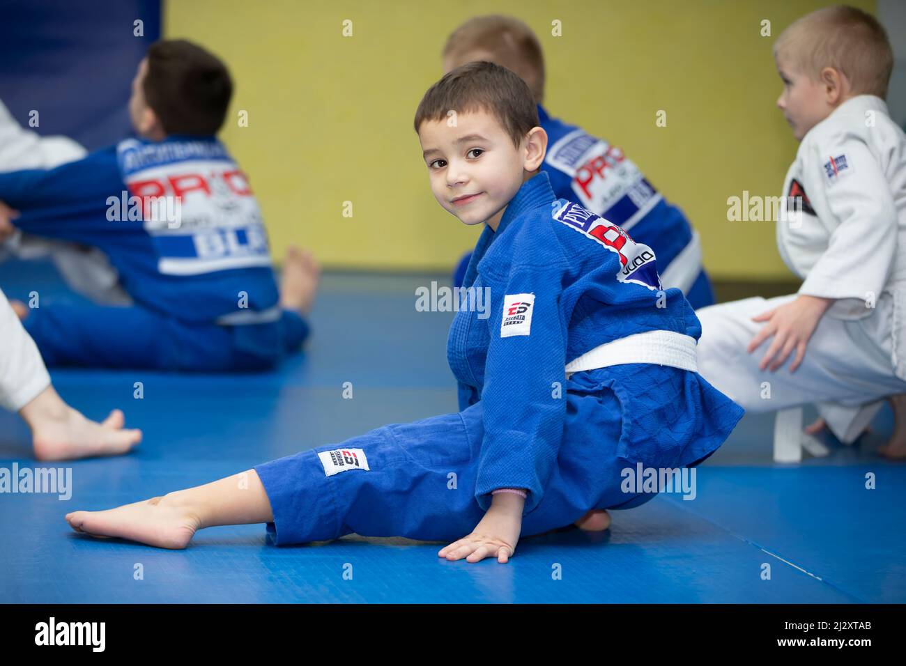 École de Judo pour enfants. Un petit garçon est engagé dans le judo dans un kimano bleu. Banque D'Images