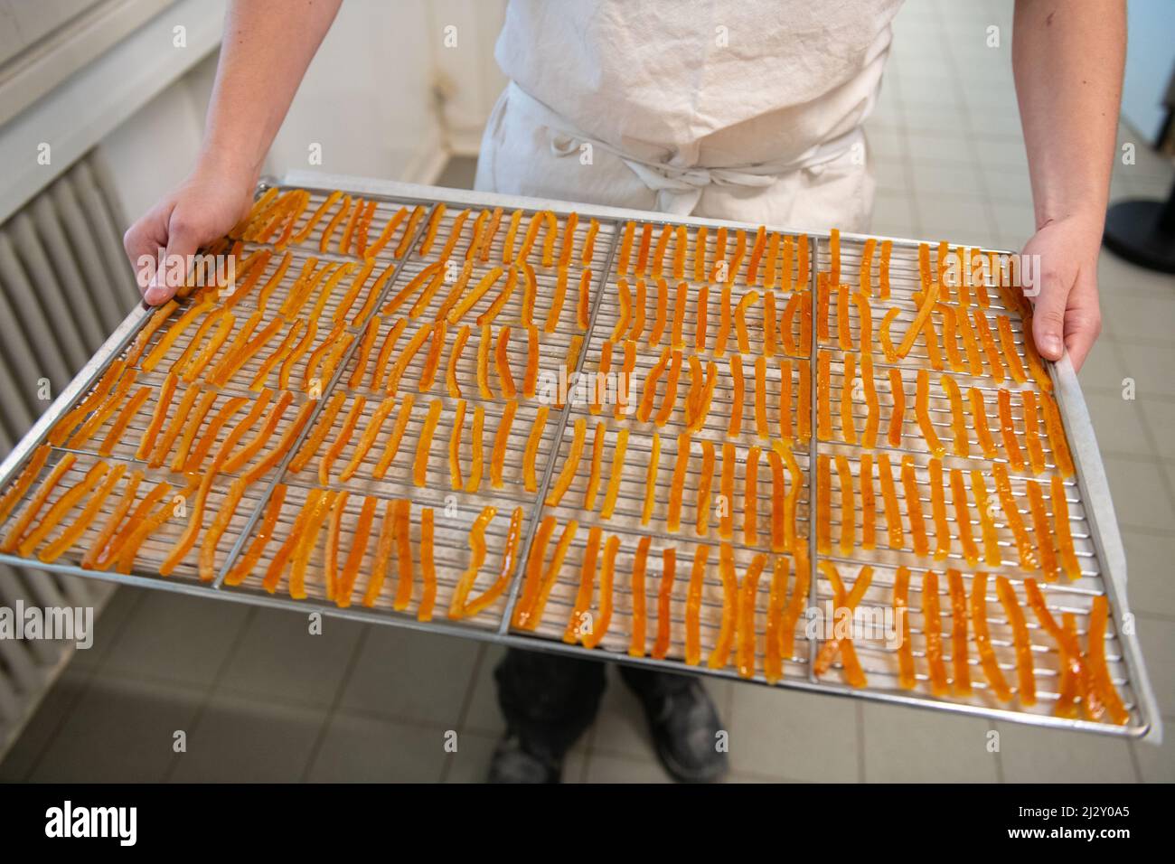 Chocolat dans la Chocolaterie Lionneton, chocolaterie dans le sud-est de la France: Fabrication de "orangettes", pâtes à l'écorce d'orange confites enrobées dans un Th Banque D'Images