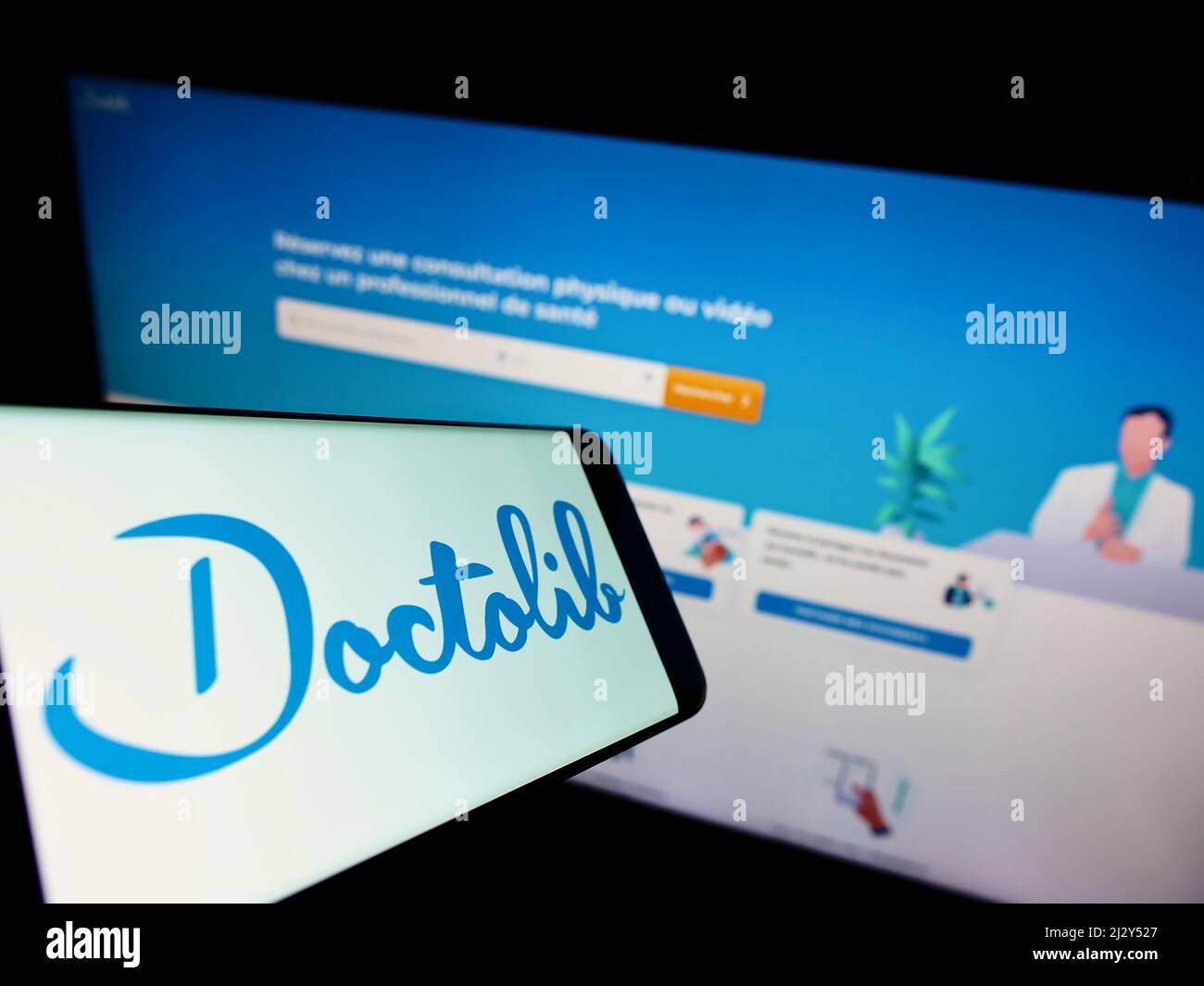 Téléphone mobile avec logo de la société française de santé Doctolib SAS sur écran en face du site web des entreprises. Effectuez la mise au point à droite de l'écran du téléphone. Banque D'Images