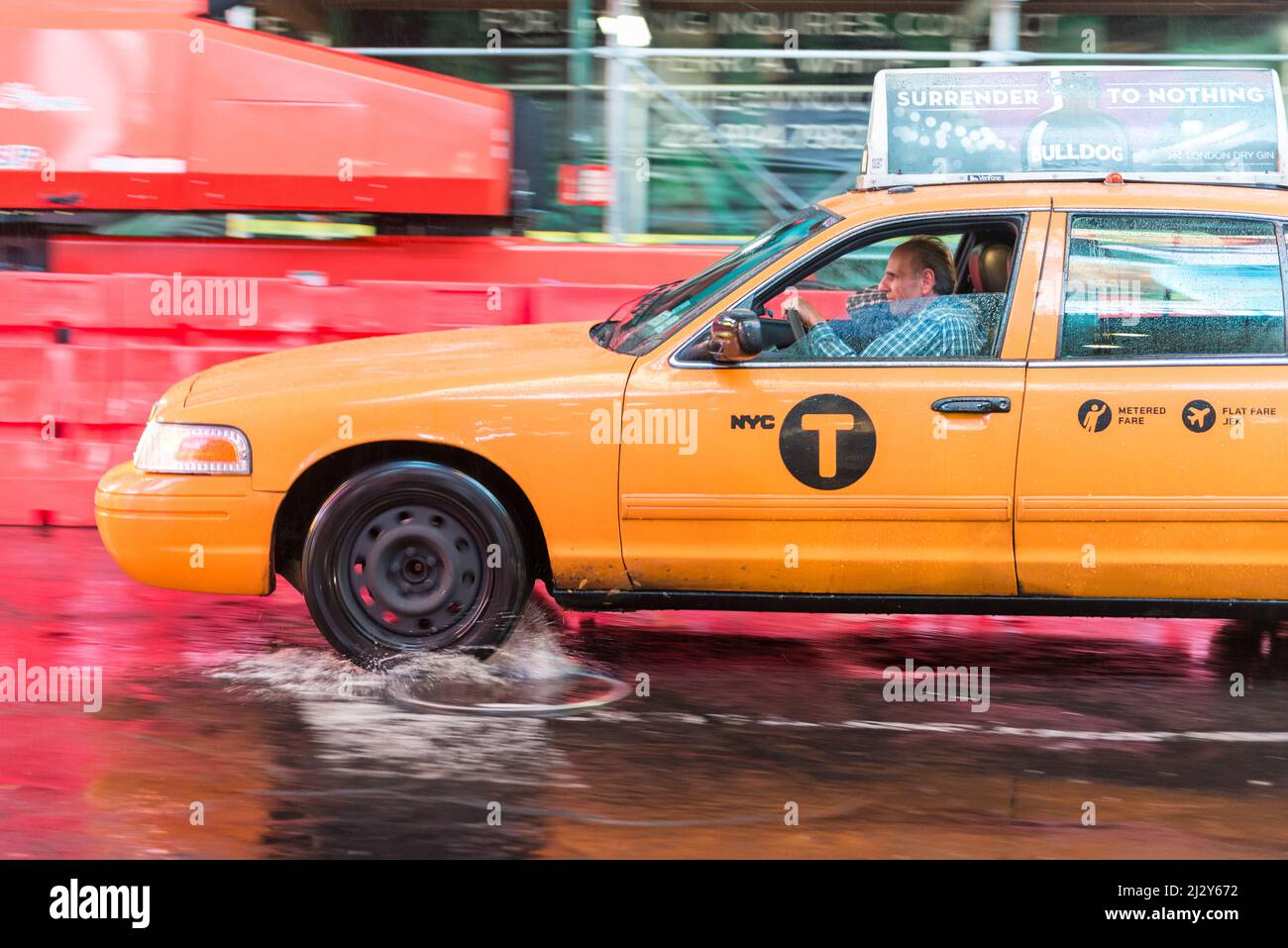 NEW YORK CITY, NY/USA - 22th OCTOBRE 2014 : un taxi éclabousse dans un étang de pluie, dans la région de Times Square, 22nd octobre 2014, New York City, NY, ÉTATS-UNIS. Banque D'Images