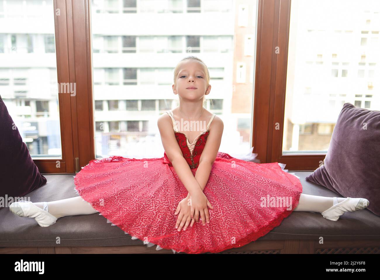 Jeune fille souriante rêvant de devenir danseuse de ballet professionnelle, école de danse classique. La petite ballerine s'étire contre le vent Banque D'Images