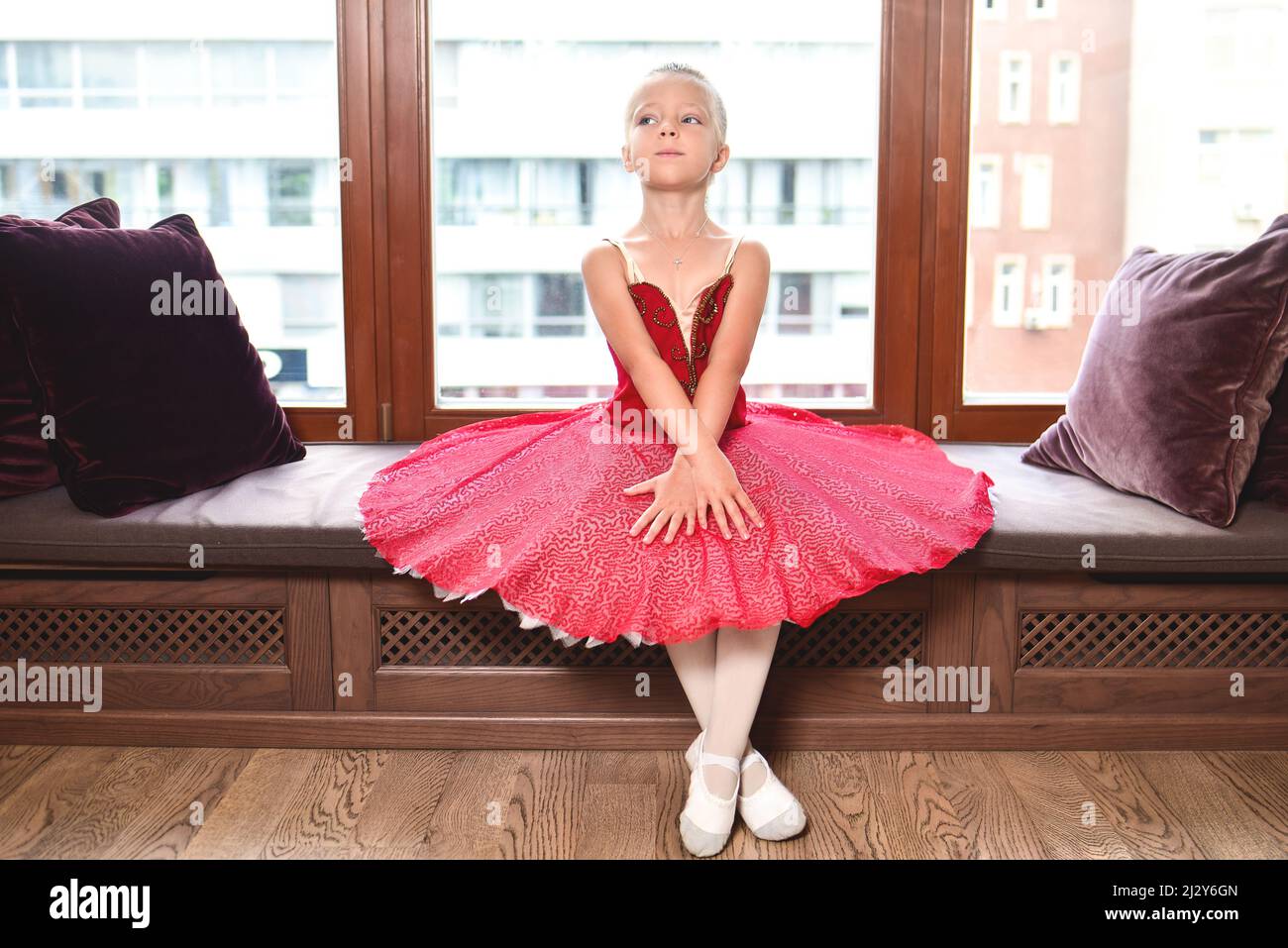 Jeune fille souriante rêvant de devenir danseuse de ballet professionnelle, école de danse classique. La petite ballerine s'étire contre le vent Banque D'Images