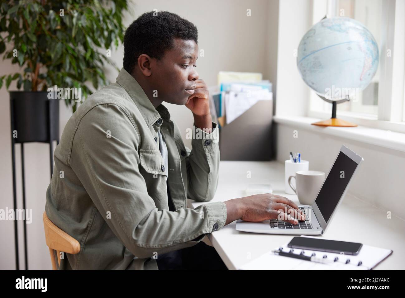 Jeune homme d'affaires Entrepreneur travaillant à la maison sur ordinateur portable Banque D'Images