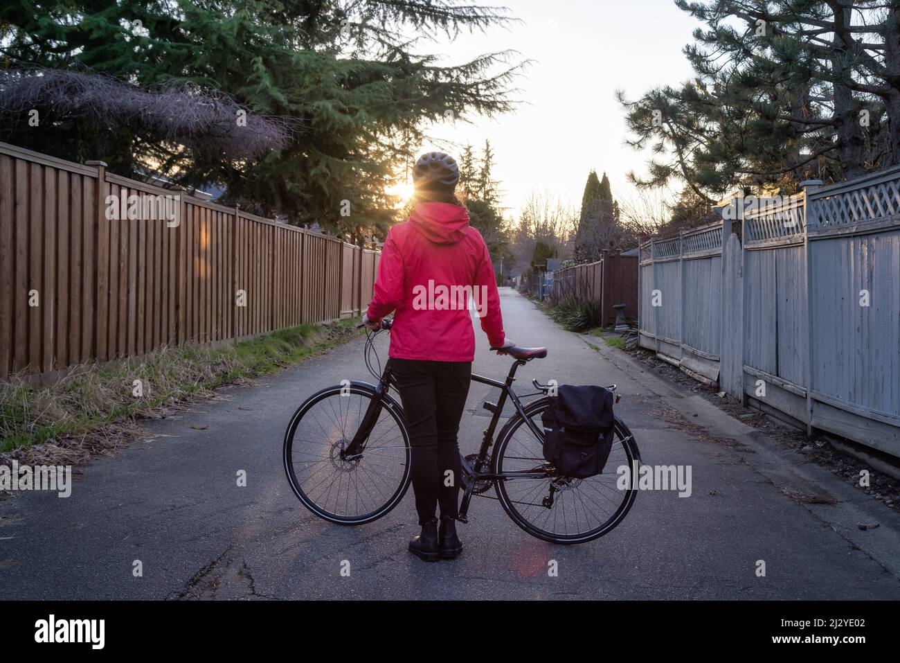 Femme aventureuse debout avec un vélo dans une allée dans la banlieue de Modery City Banque D'Images
