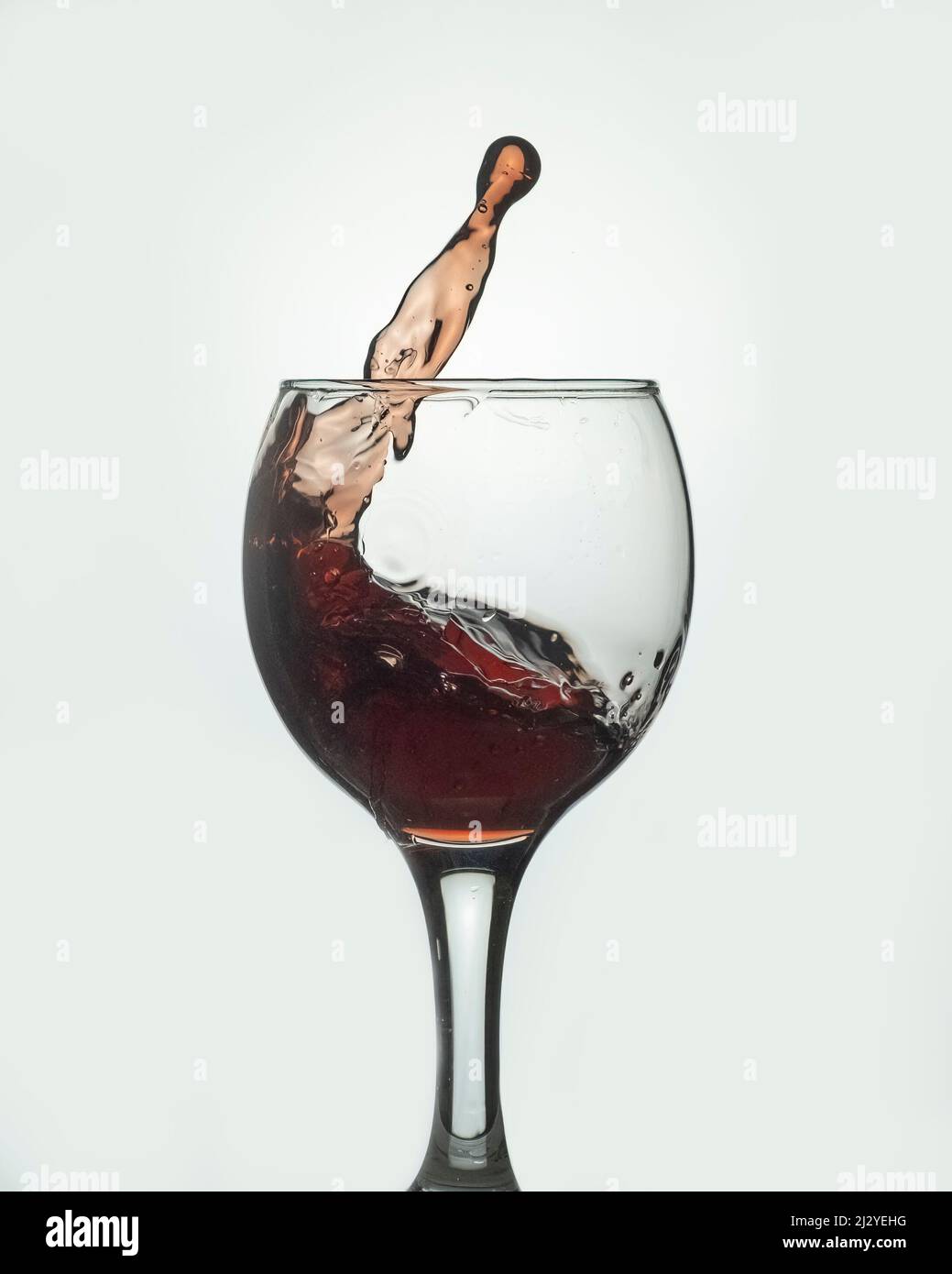 verre de jus de grenade avec des éclaboussures sur fond clair Banque D'Images