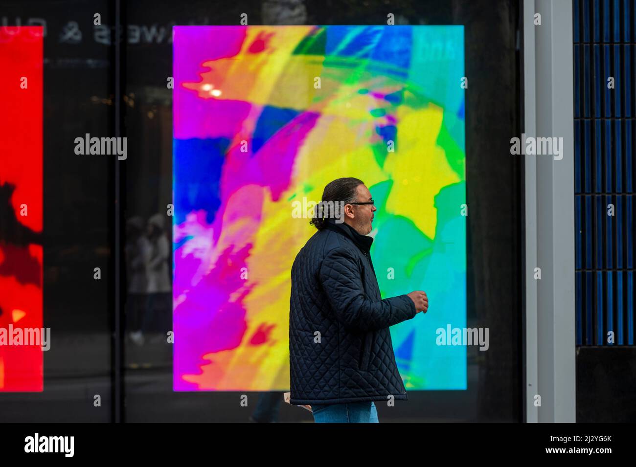 Londres, Royaume-Uni. 4 avril 2022. Un membre du public passe MVP (la peinture la plus précieuse), une nouvelle commission spécifique au site par l'artiste Jonas Lund qui est exposé au W1 Curats sur Oxford Street. 512 tableaux numériques sont en vue sur 36 écrans. La série sera mise en vente sous forme de NFTS (jetons non fongibles) sur le marché Aorist à partir d'avril 11 et se termine par une présentation finale à Venise, avec les jours de prévisualisation de la Biennale de Venise 59th (du 20 au 22 avril 2022). Credit: Stephen Chung / Alamy Live News Banque D'Images