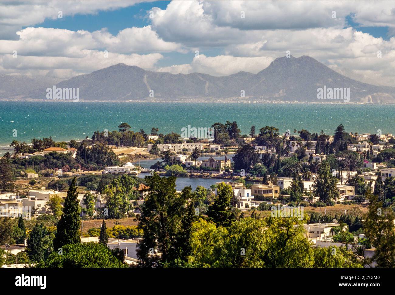 Carthage, Tunisie. Ports puniques, maintenant ressemblant à de petits lacs bordés de maisons luxueuses, date à partir de la 4ème. Siècle avant J.-C. Baie de Tunis et le volcan connu sous le nom de Bou Kornein sont à l'arrière-plan. Banque D'Images