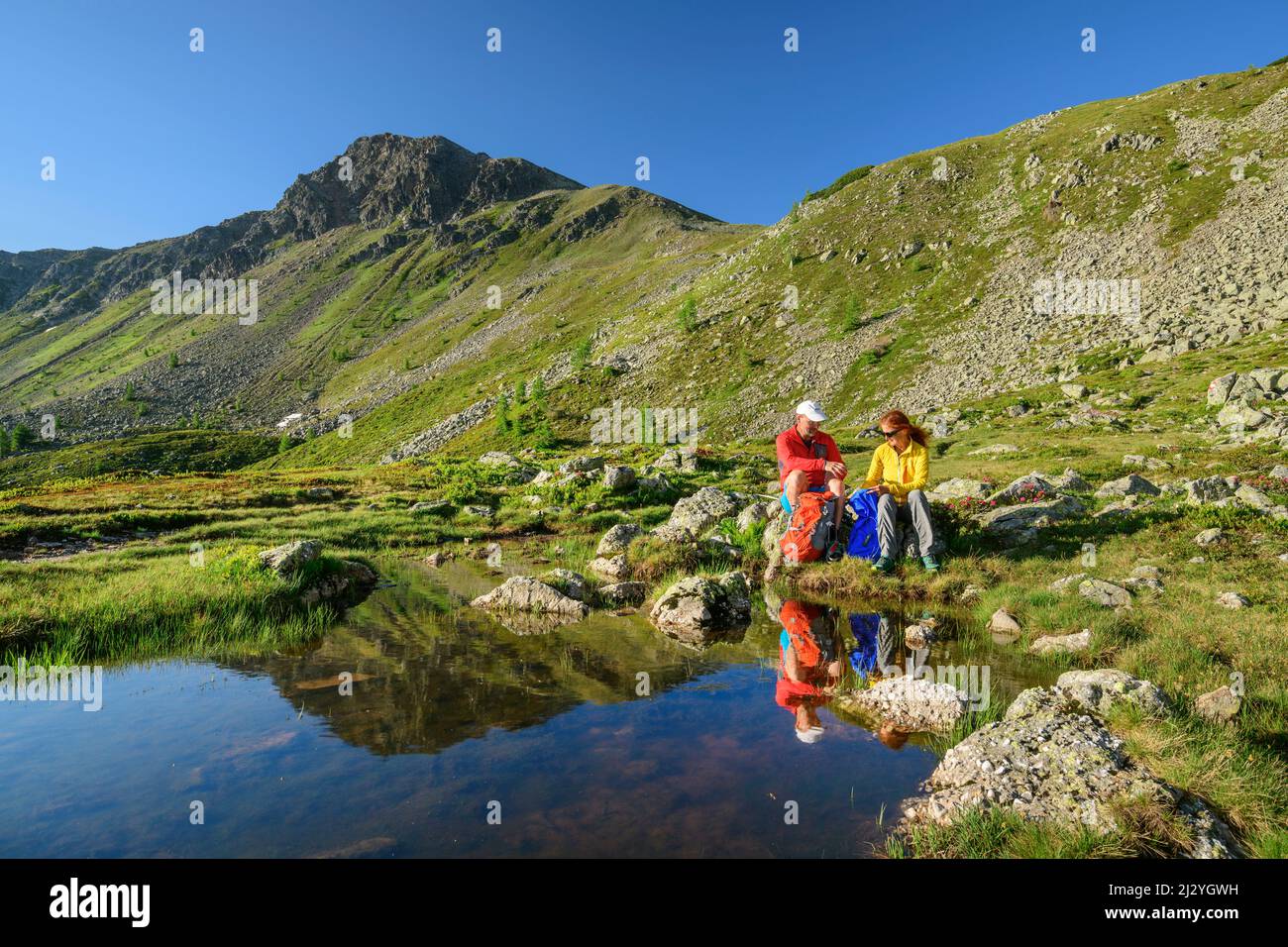 Homme et femme en randonnée faites une pause à Rosaninsee, Rosaninsee, Königstuhl, Nockberge, Nockberge-Trail, Parc de la biosphère de Nockberge, Alpes de Gurktal, Carinthie, Autriche Banque D'Images