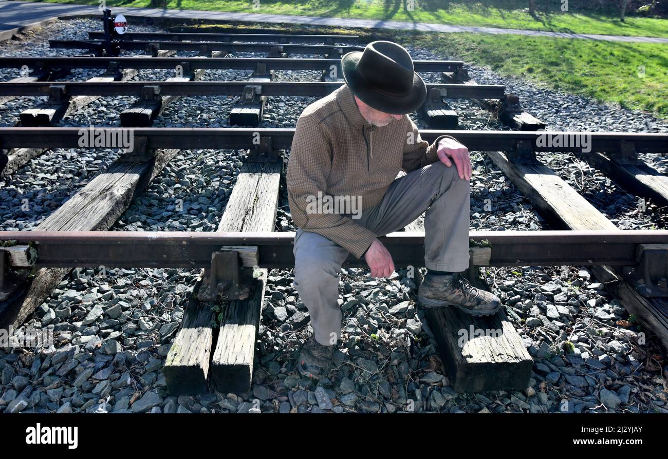 Homme assis sur la ligne de chemin de fer Banque D'Images