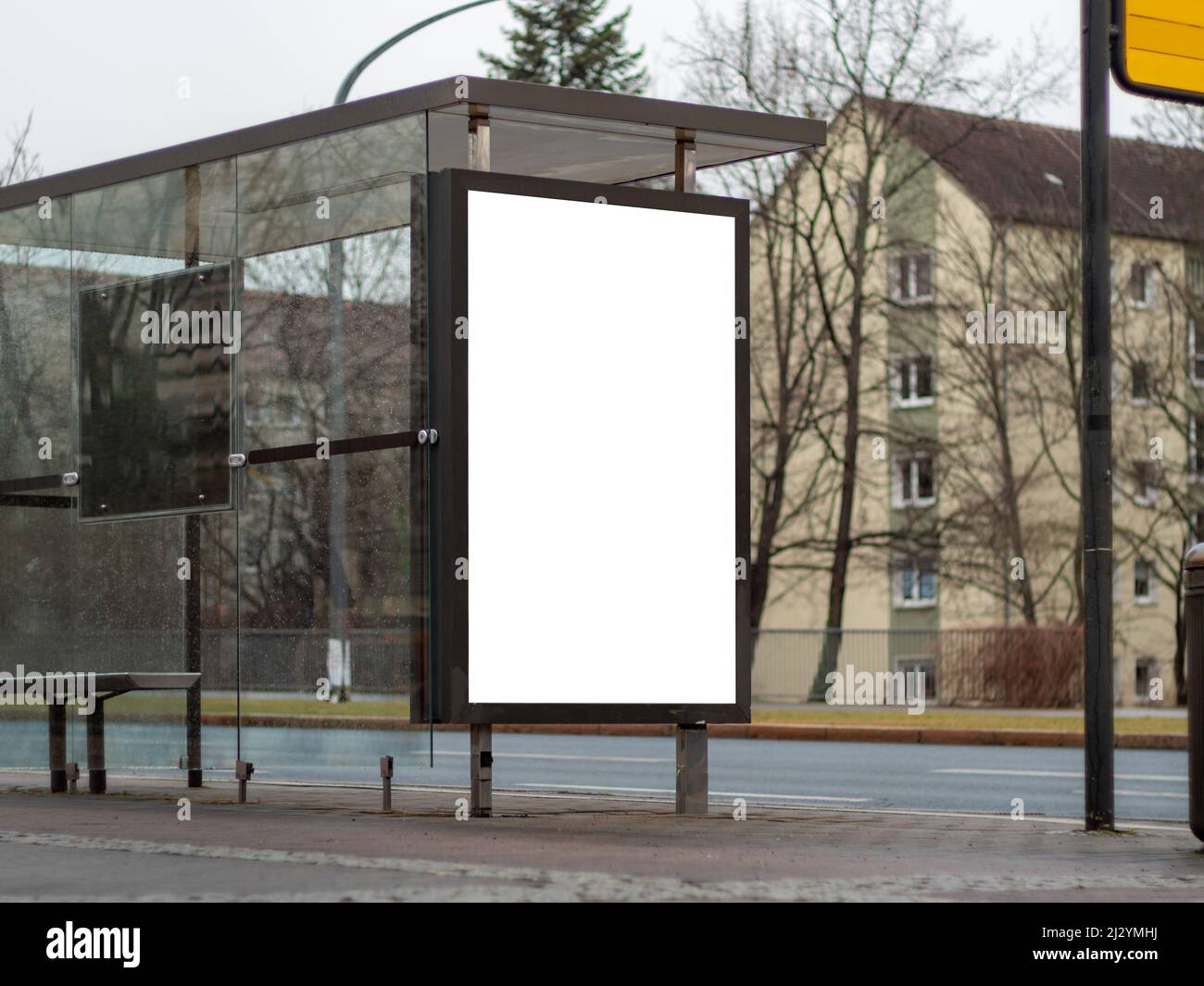 Une publicité vide s'affiche dans un abri de bus dans une ville. Maquette de panneau vierge pour le marketing dans la sphère publique. Modèle pour tester une conception publicitaire. Banque D'Images