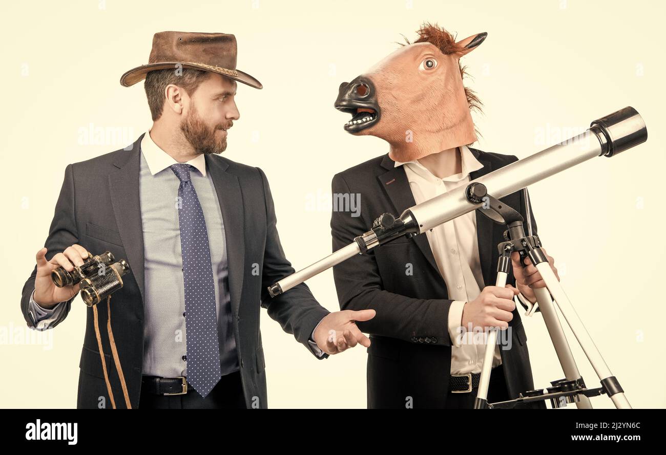 Homme d'affaires dans le masque de tête de cheval tenir le télescope et homme de cow-boy avec des jumelles, vision d'affaires Banque D'Images